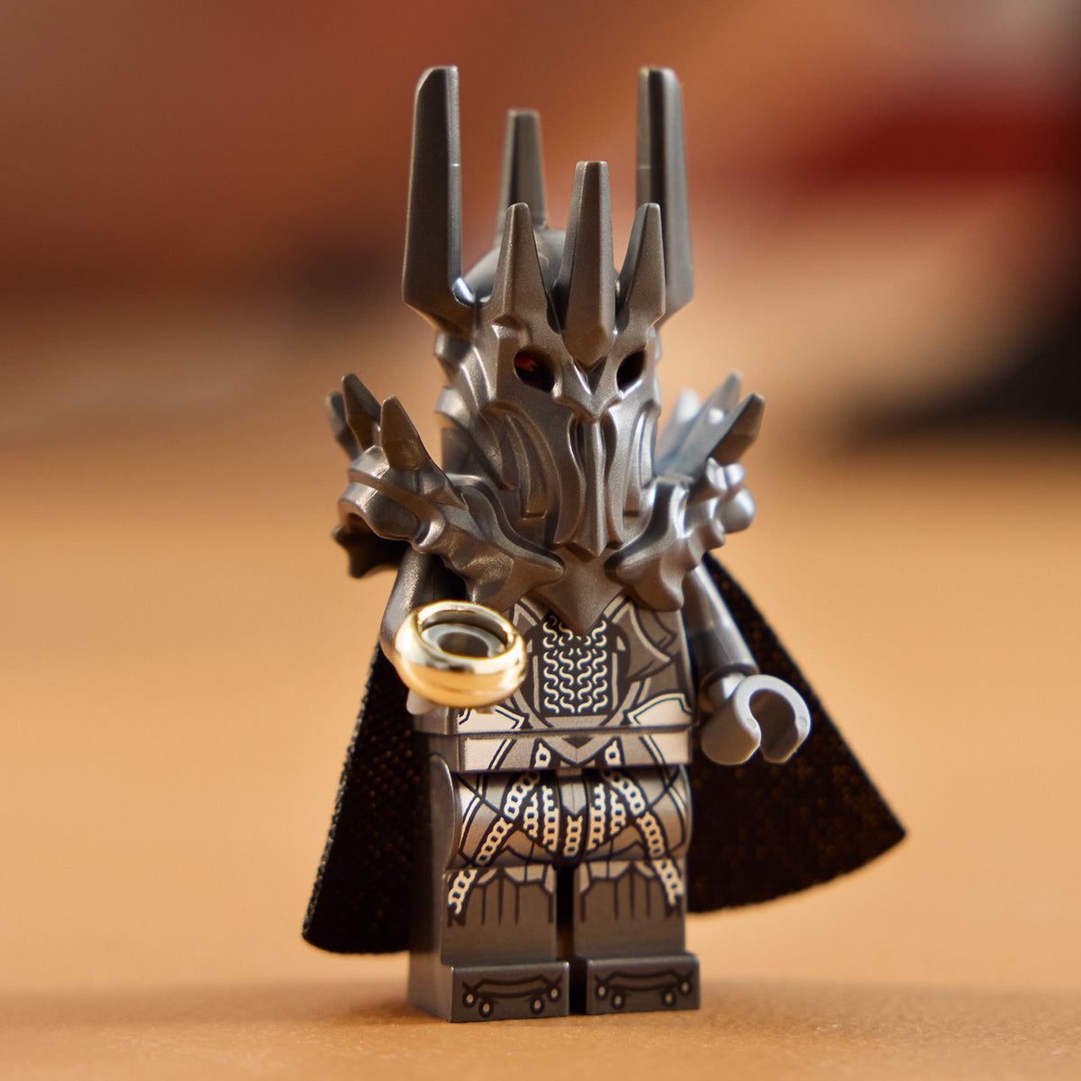 LEGO Figur von Sauron mit schwarzem Umhang, detailliertem Helm mit Spitzen und goldfarbenem Ring in der Hand