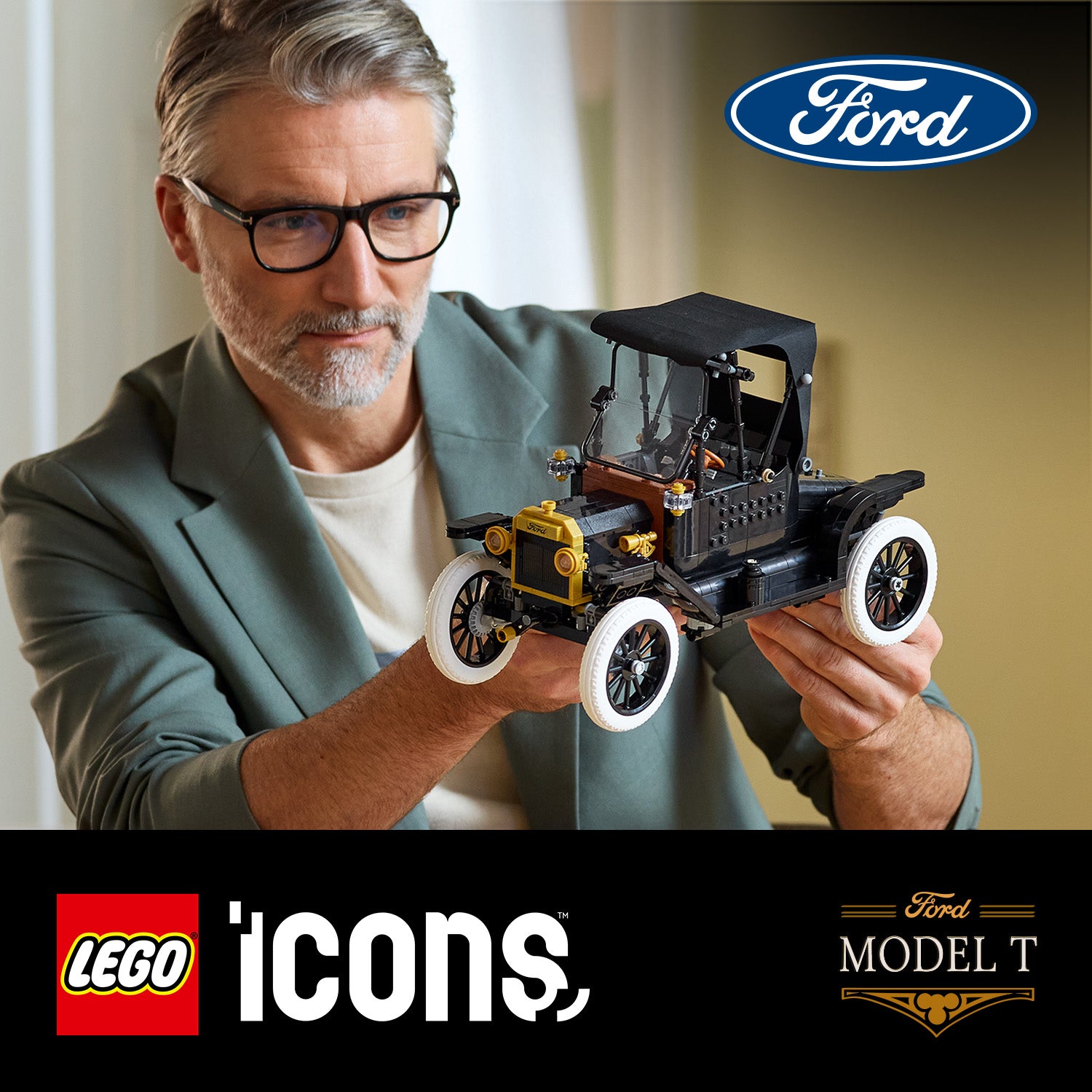 Person hält ein LEGO Modell des Ford Model T mit sichtbaren weißen Reifen und schwarzem Verdeck vor neutralem Hintergrund
