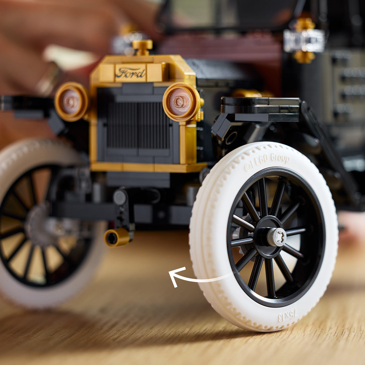 Nahaufnahme eines LEGO Modells des Ford Model T mit weißen Reifen und goldfarbenen Details am Kühlergrill