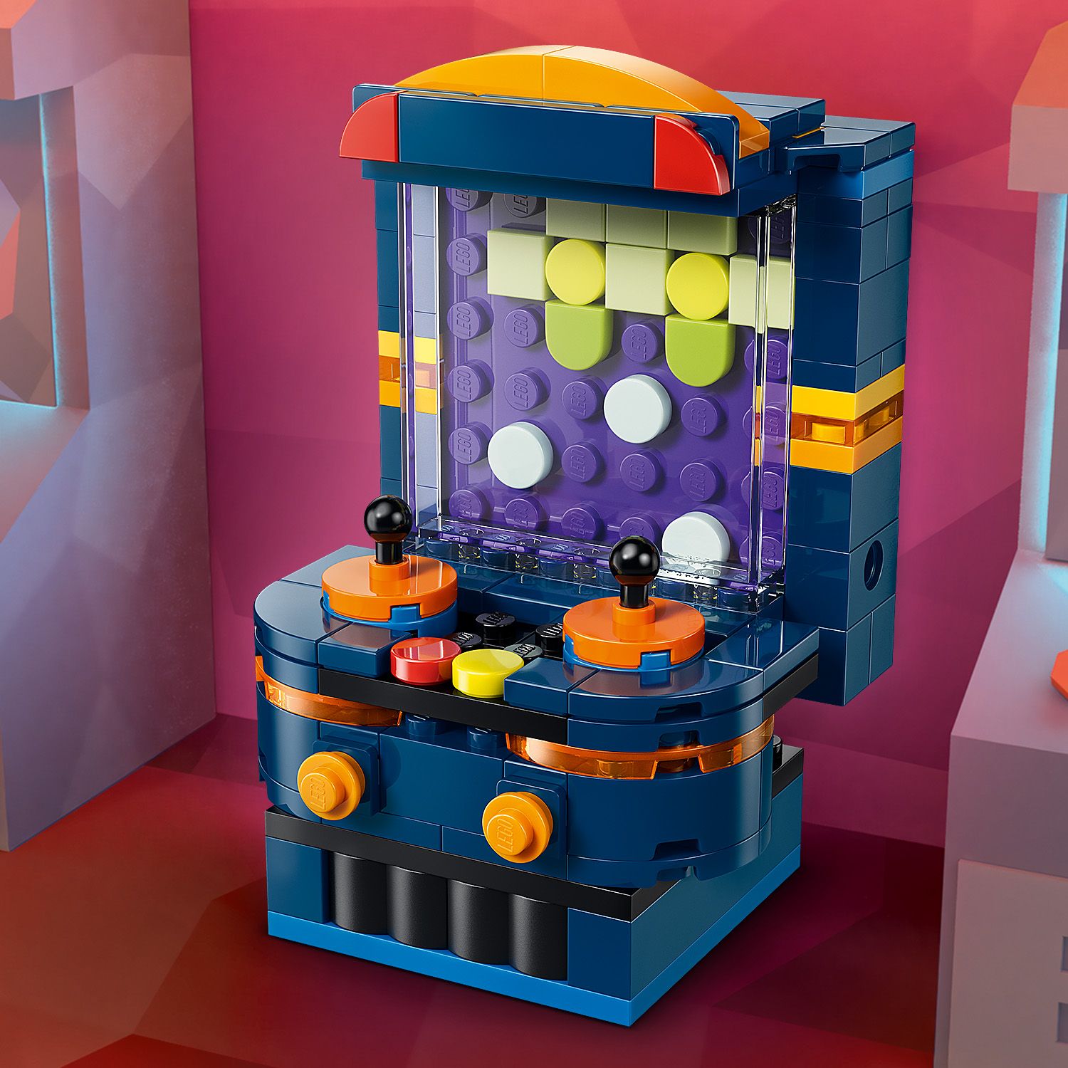 LEGO Creator Retro-Spielkonsole aus dunkelblauen, orangen und gelben Bausteinen mit zwei Joysticks und einem Bildschirm mit pixelartiger Darstellung.