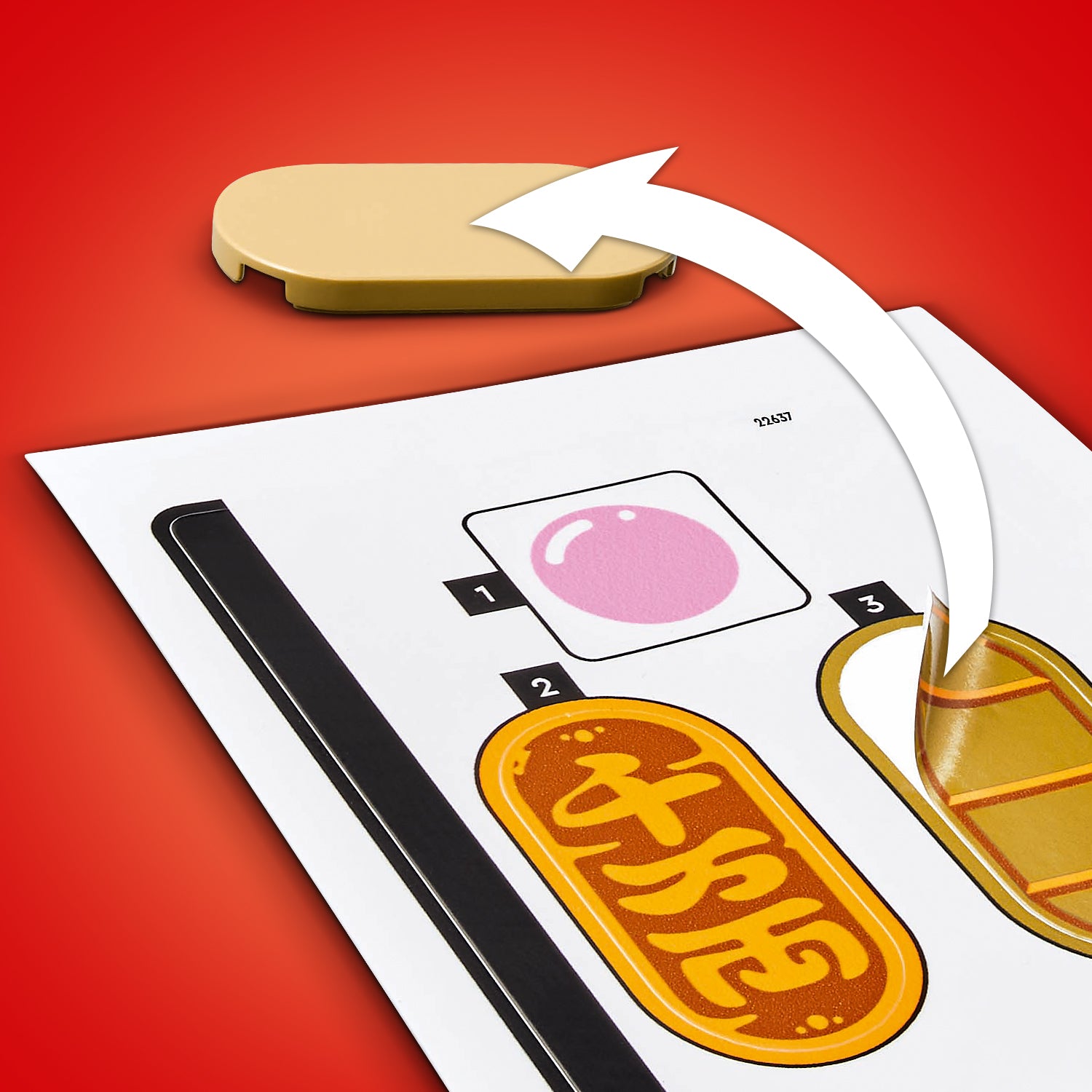 Ein beige-farbener LEGO Stein liegt auf einer roten Fläche neben einer Anleitung mit einem Pfeil, der zeigt, dass der Stein auf eine markierte Stelle mit einem rosa Kreis gesetzt werden soll.