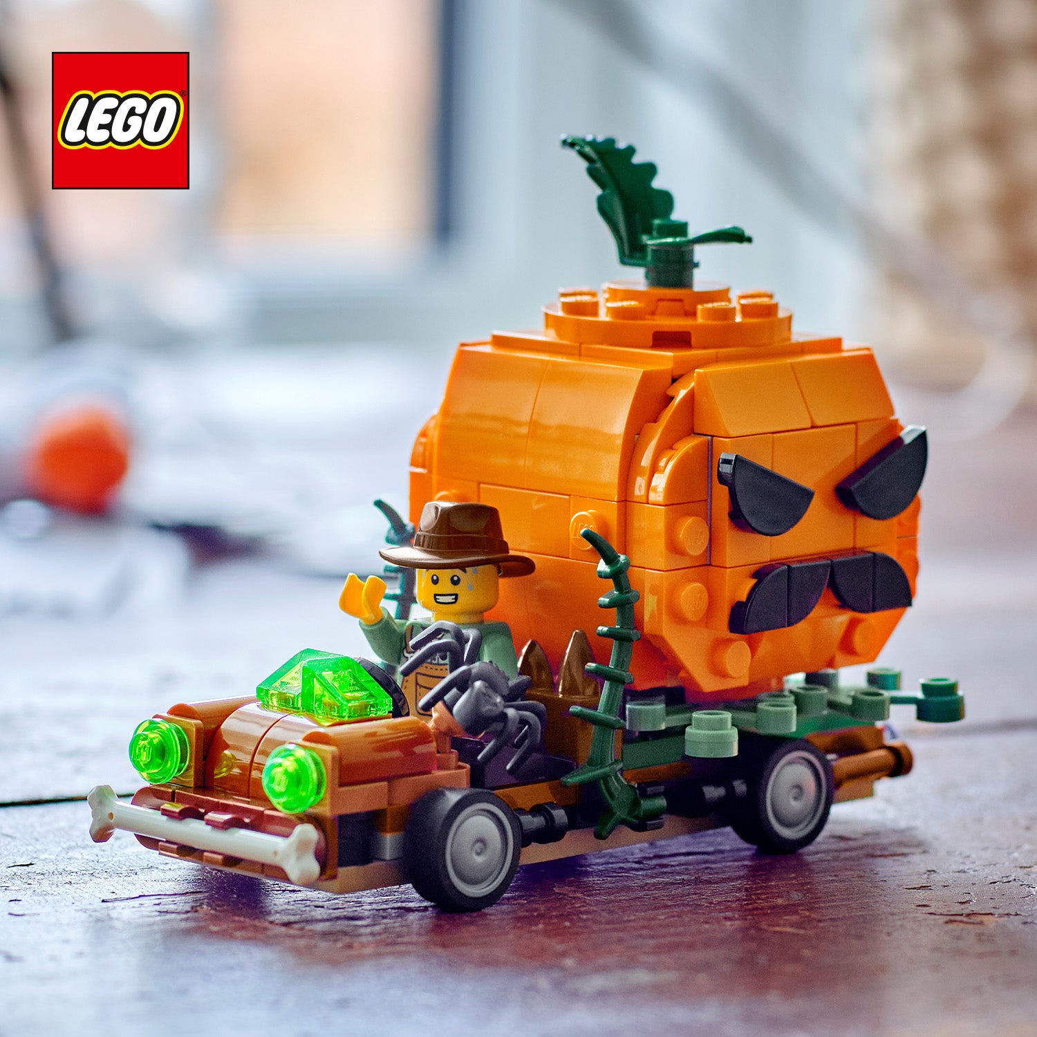 LEGO Modell eines Pickups mit großem Halloween-Kürbis als Anhänger und Minifigur mit Hut am Steuer