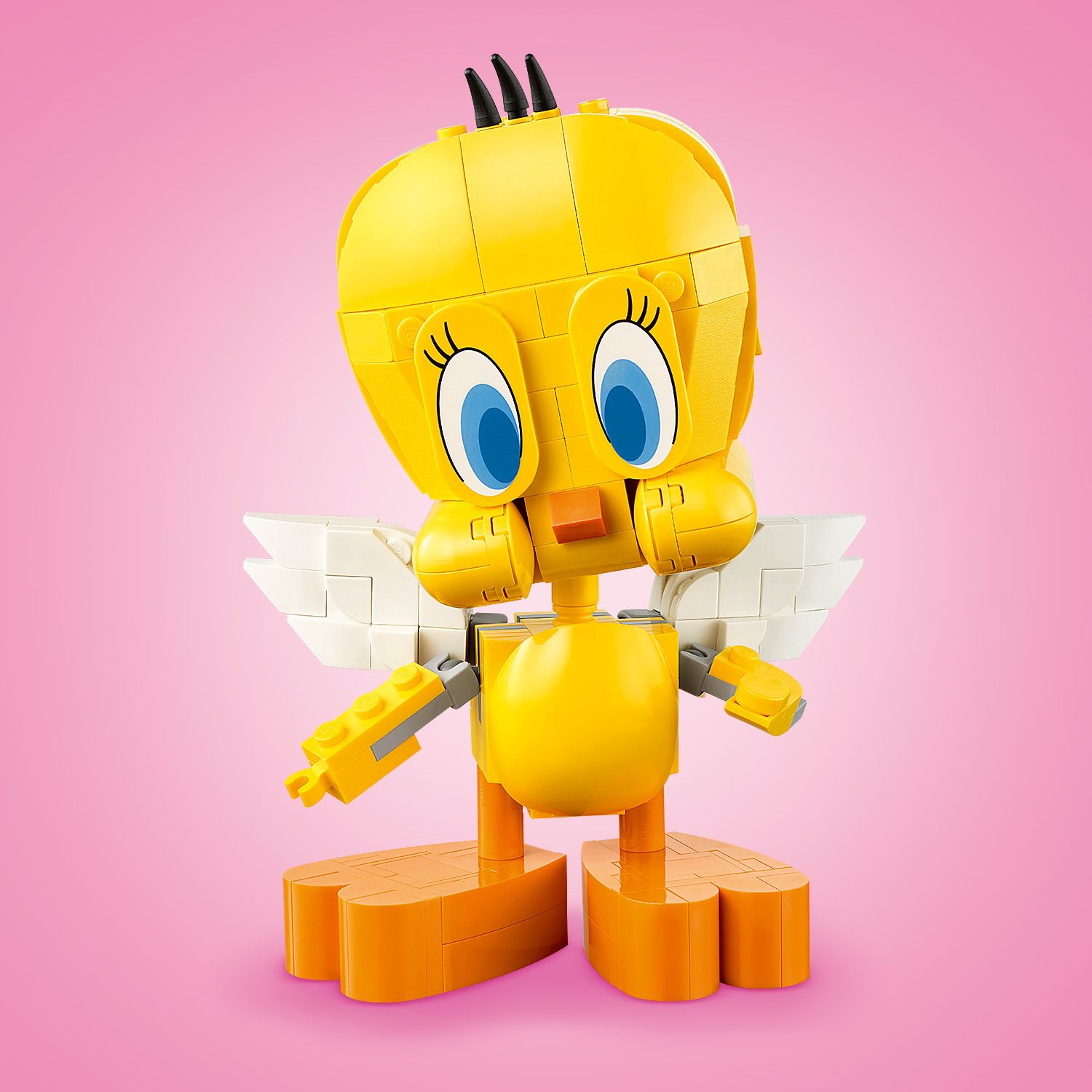 Gelbes LEGO Modell von Tweety mit großen blauen Augen, weißen Flügeln und orangen Füßen vor rosa Hintergrund.