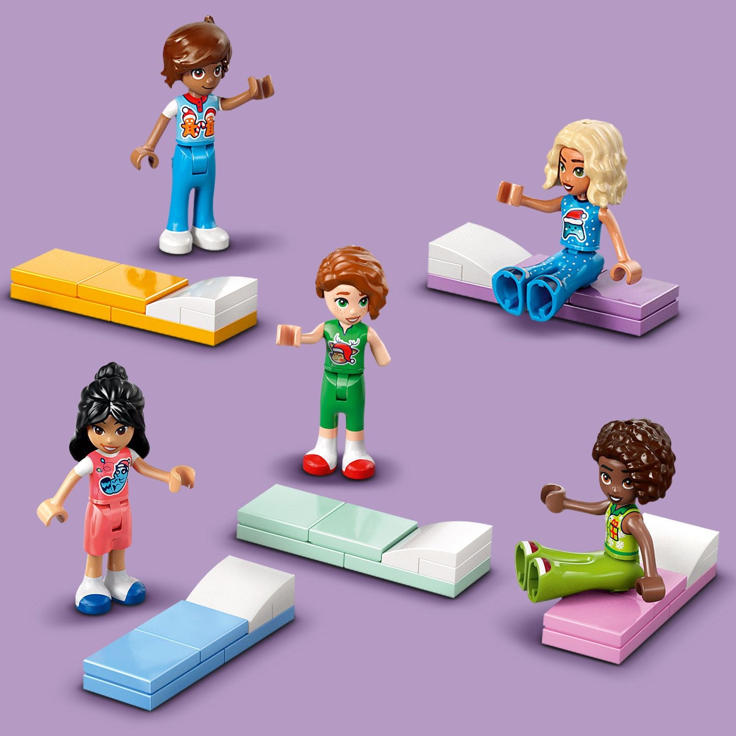 5 Friends-Figuren, 2 sitzen 3 stehen neben Betten, welche aus LEGO gebaut sind. Lila Hintergrund