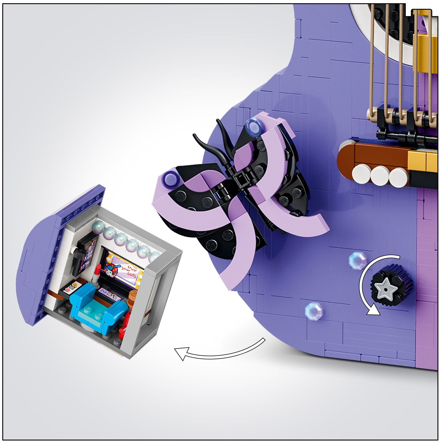 Nahaufnahme eines lila LEGO Gitarrenkorpus mit einem schwarzen und lila Schmetterlingsmotiv und einem abnehmbaren, kleinen LEGO Raum mit einem Bildschirm und Möbeln