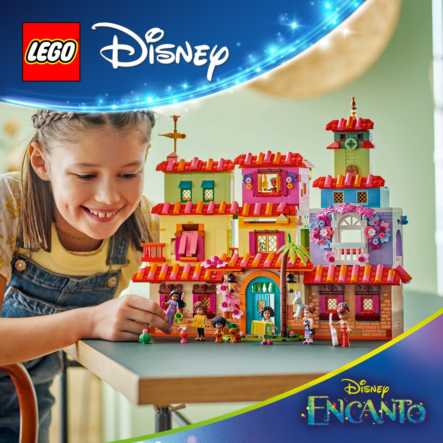 Kind spielt mit dem LEGO Set "Das magische Haus der Madrigals" aus Disney Encanto, das ein farbenfrohes, mehrstöckiges Haus mit Figuren und Pflanzen zeigt.