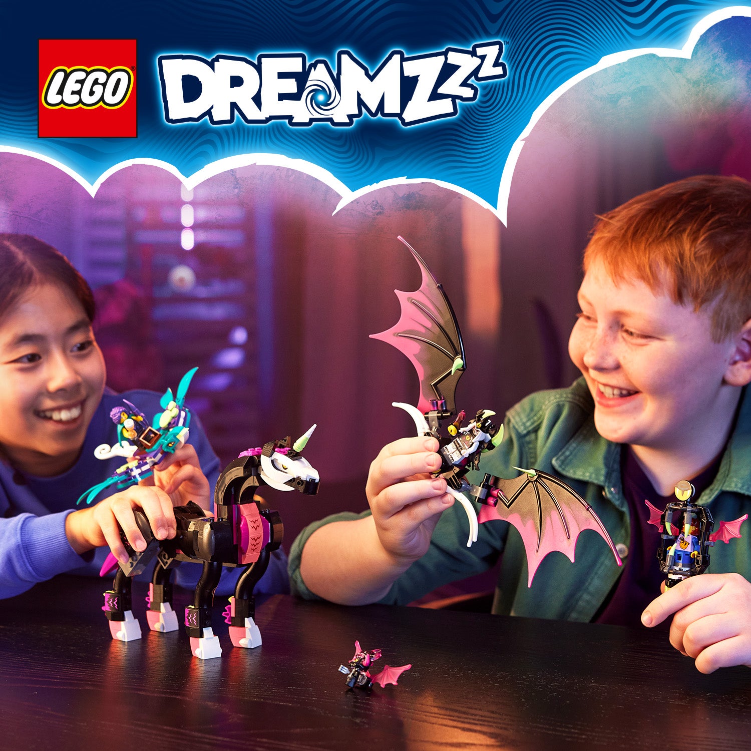 Zwei Kinder spielen mit LEGO DreamZzz-Figuren: ein schwarzes Einhorn mit pinken Hufen und ein geflügelter Drache mit braunen Flügeln.