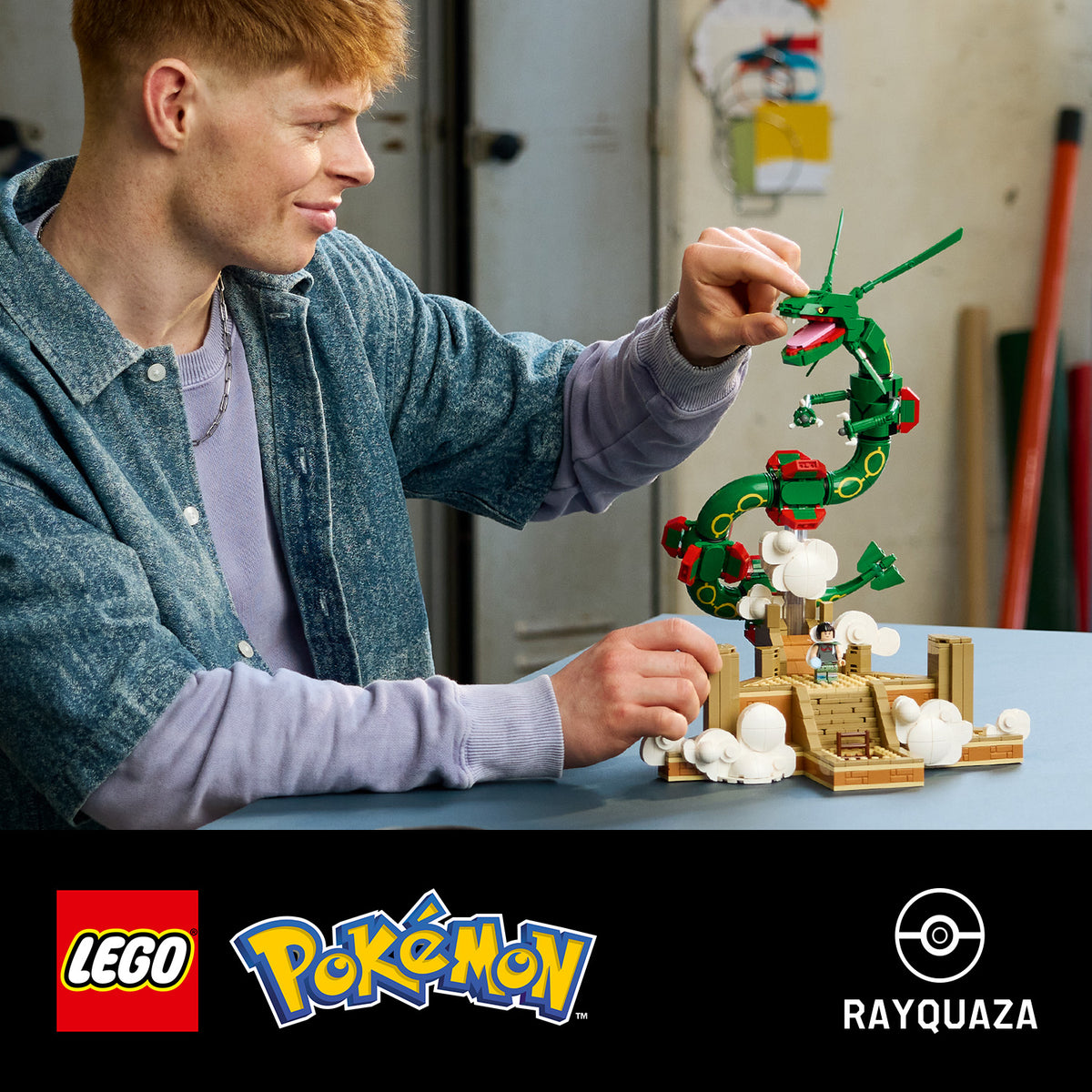 Junger Mann baut grünes LEGO Modell des Pokémon Rayquaza mit Wolken- und Treppenelementen auf einem Tisch