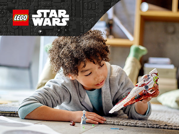 Kind liegt auf dem Bauch auf einem Teppich und hält ein LEGO Star Wars Raumschiff in der Hand
