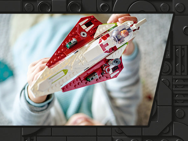 Kind hält LEGO Star Wars Obi-Wan Kenobis Jedi-Sternenjäger aus rotem und weißem Kunststoff mit sichtbarer Minifigur im Cockpit