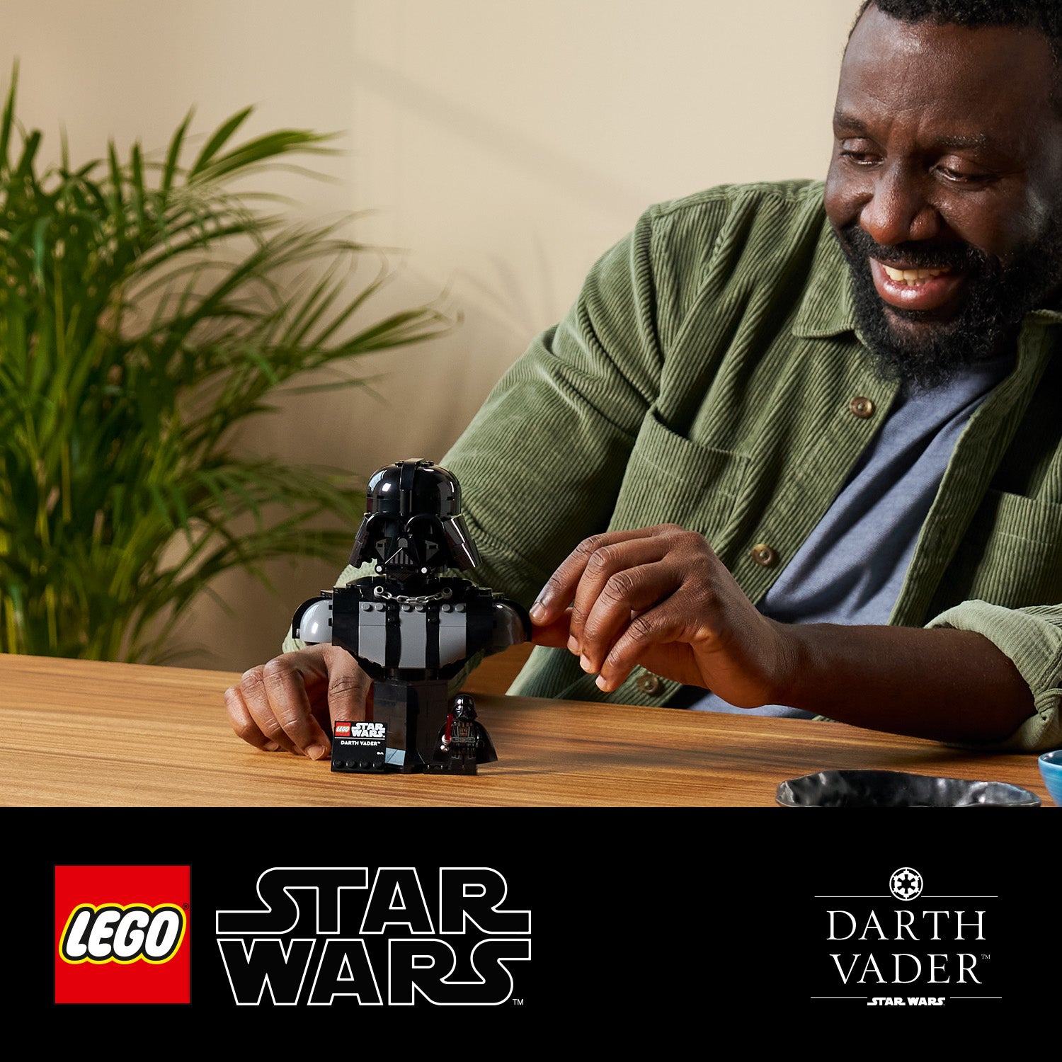 Person baut eine LEGO Star Wars Darth Vader Büste auf einem Holztisch