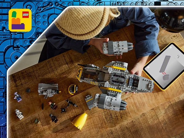 Kind baut LEGO Star Wars Raumschiff Razor Crest auf Holztisch mit mehreren Minifiguren und Tablet mit Bauanleitung