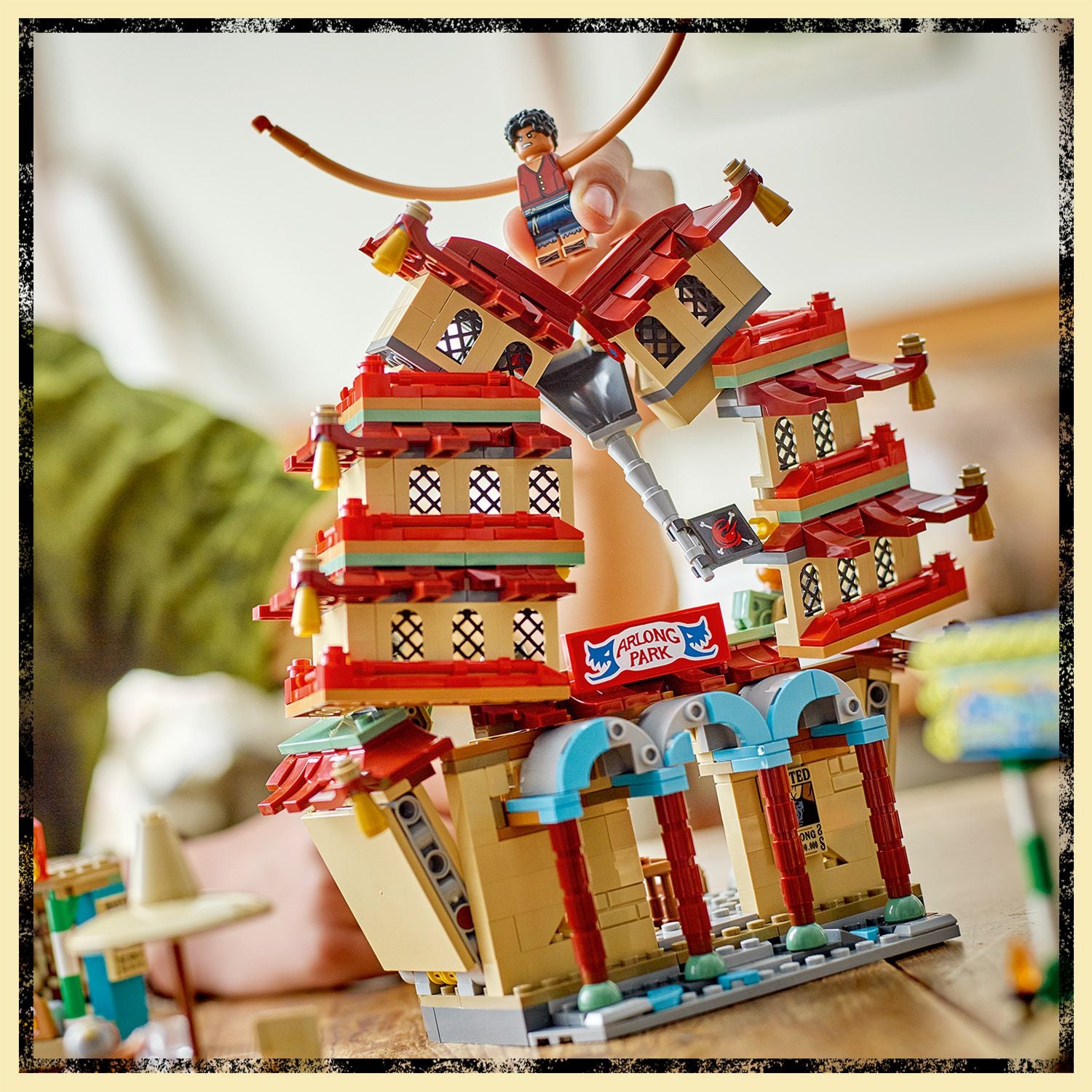 LEGO Set mit asiatisch inspirierten Gebäuden und einem roten Schild mit der Aufschrift 'ARLONG PARK'.
