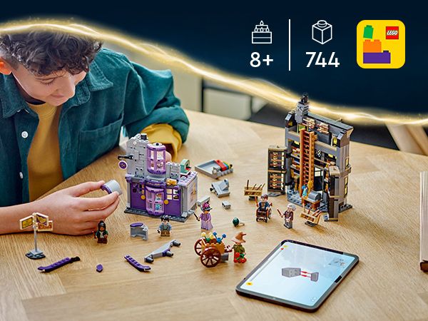 LEGO Harry Potter Set mit den Gebäuden Ollivanders und Madam Malkins, mehreren Minifiguren, einem Wagen und einem Tablet auf einem Holztisch.