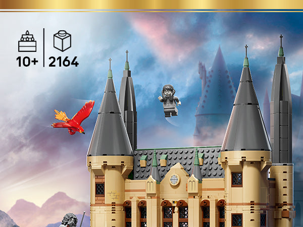 LEGO Modell des Hogwarts-Ostflügels mit vier Türmen, einer fliegenden Figur und einem roten Vogel vor einem Himmel mit Wolken