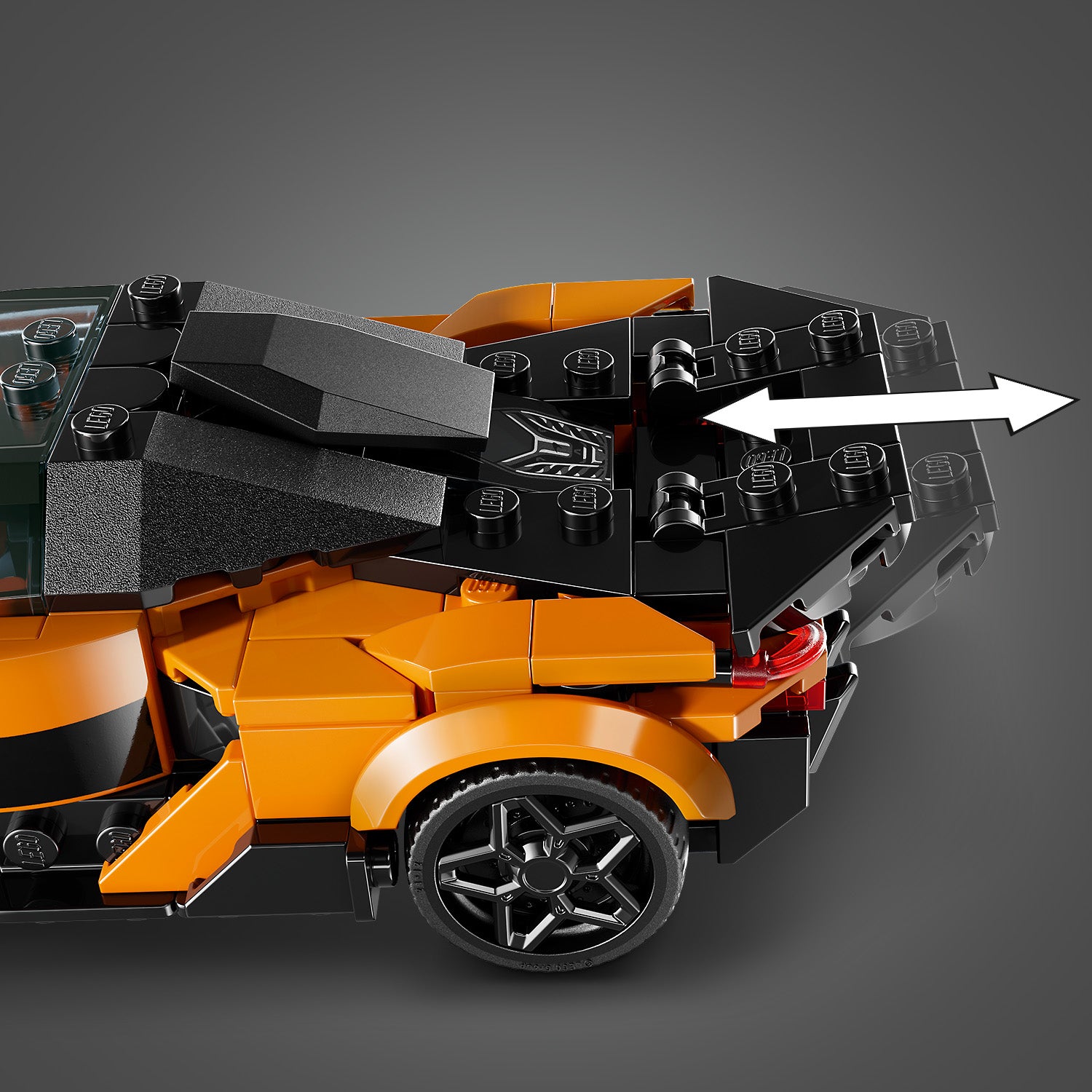 Nahaufnahme des Heckteils eines orange-schwarzen LEGO McLaren Speed Champions Modells mit ausfahrbarem Heckflügel.