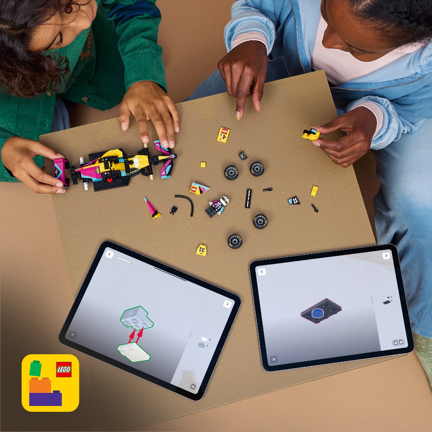 Zwei Kinder bauen an einem LEGO Rennwagen mit verstreuten LEGO Teilen auf einem Tisch, daneben zwei Tablets mit digitalen Bauanleitungen.