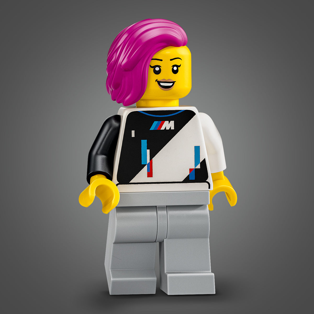 LEGO Minifigur mit pinkem Haar, lächelndem Gesicht, schwarz-weißem Oberteil mit BMW-M-Logo und grauer Hose